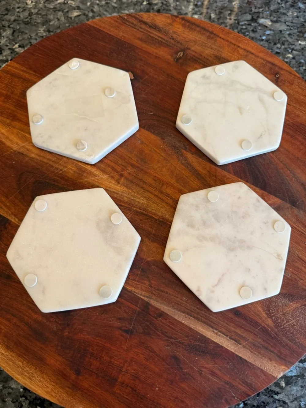 Hexagonal white marble coasters featuring a brass inlay design